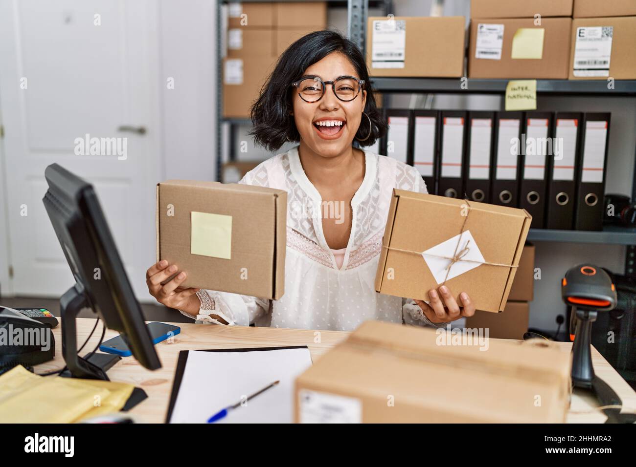 Young hispanic woman working at small business ecommerce smiling and ...