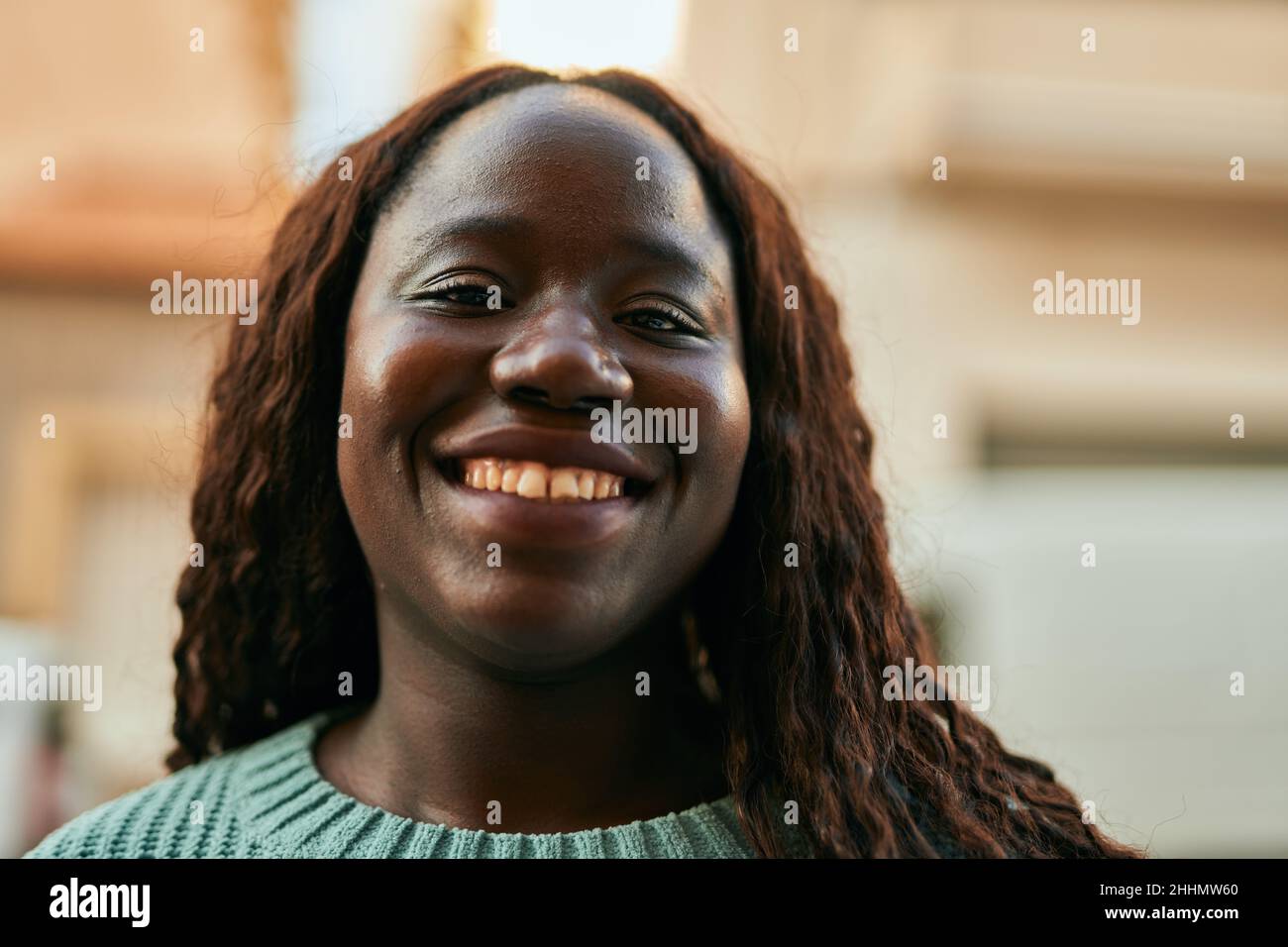 Young african woman smiling happy at the city Stock Photo - Alamy