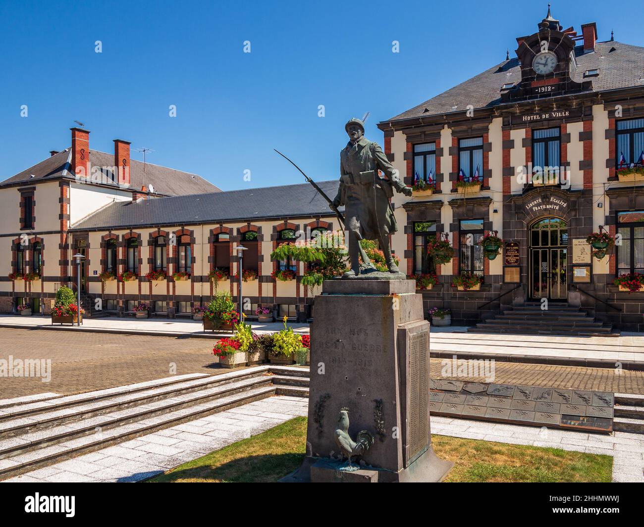 The town hall and a war memorial in the town of St Eloy les Mines in the canton of Montaigut, Pays de Combrailles in the Auvergne region of France. On Stock Photo