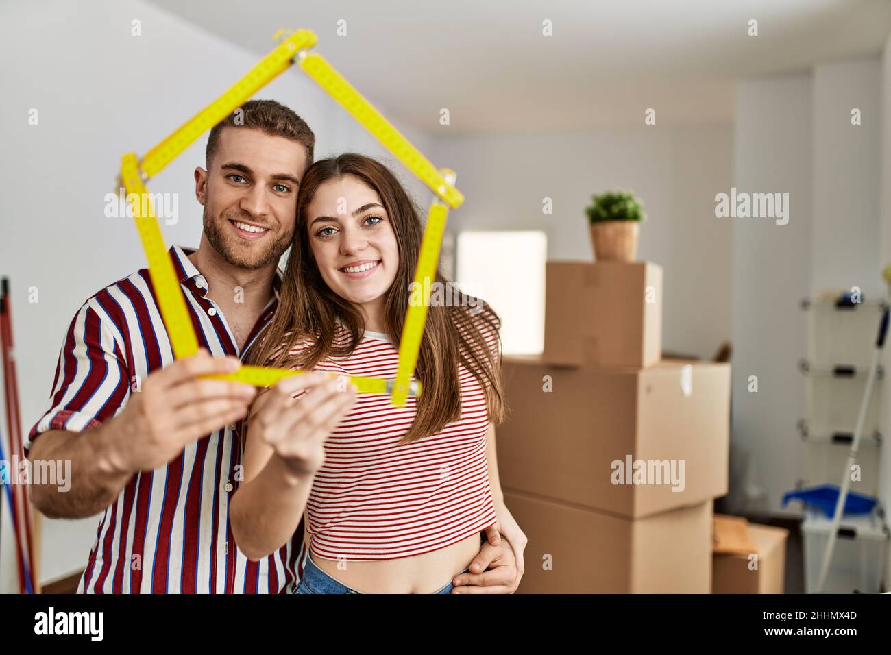 Young caucasian couple smiling happy holding house project new home ...