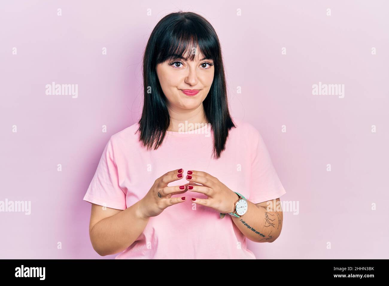 Young hispanic woman wearing casual clothes hands together and fingers ...
