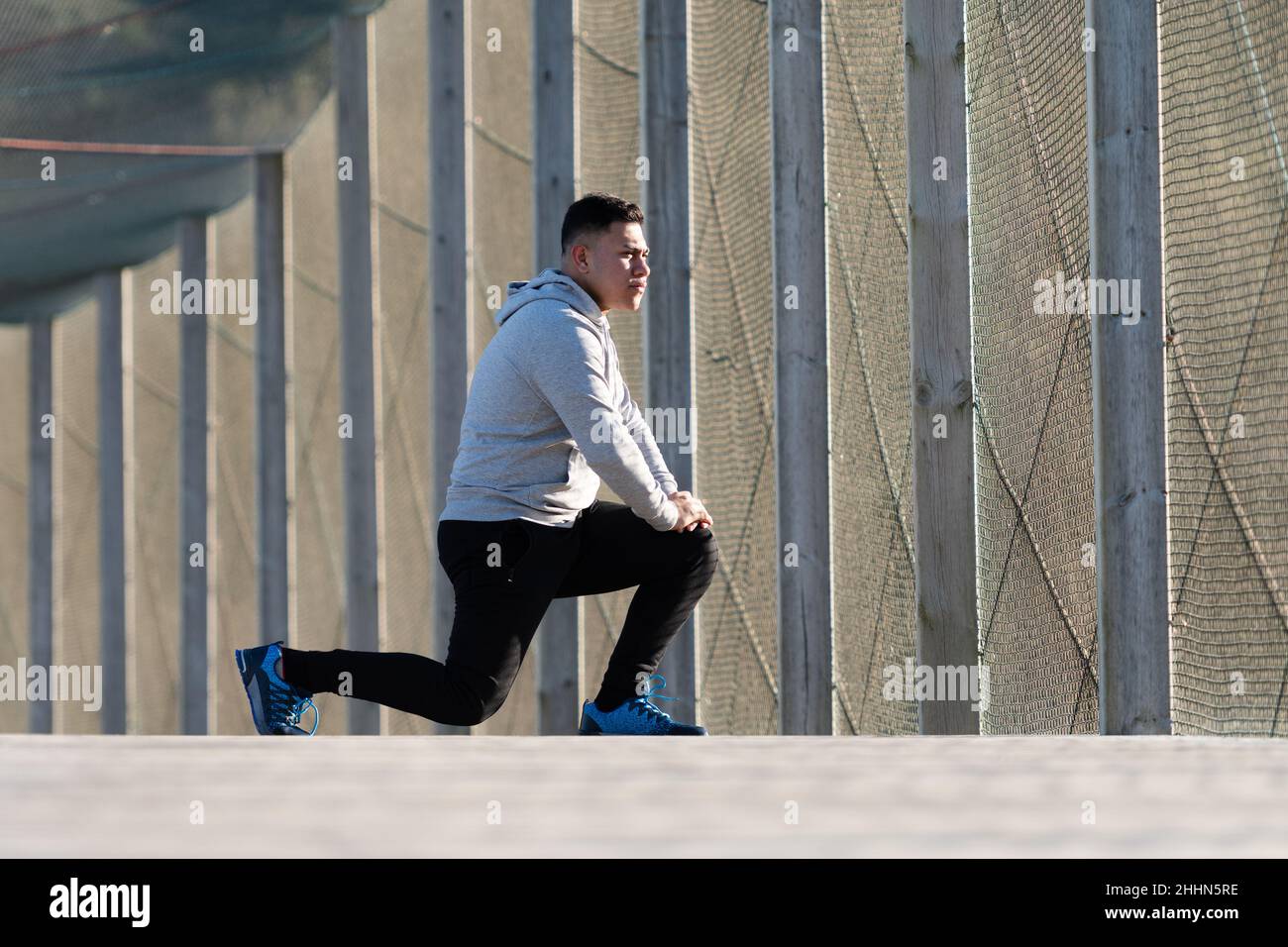 Concentrated latin man stretching outdoors in a promenade Stock Photo