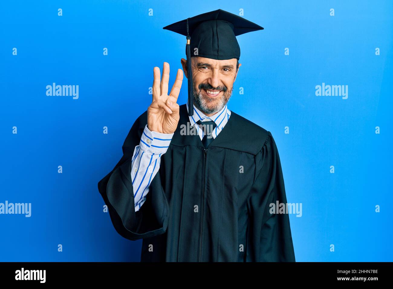 Middle age hispanic man wearing graduation cap and ceremony robe ...