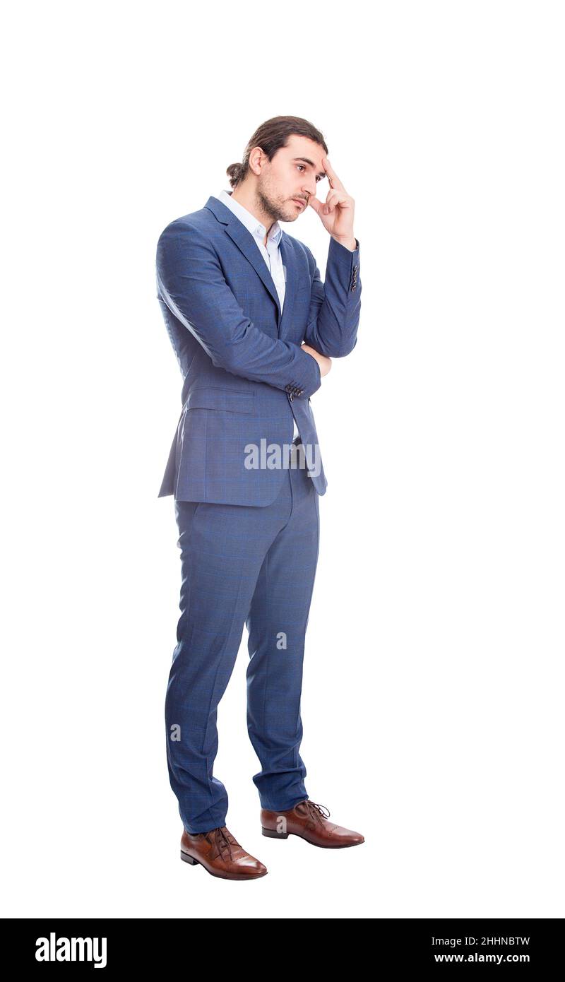 Full length portrait of thoughtful and melancholic businessman keeps hand to head, looks pensive isolated on white background. Reflective business per Stock Photo