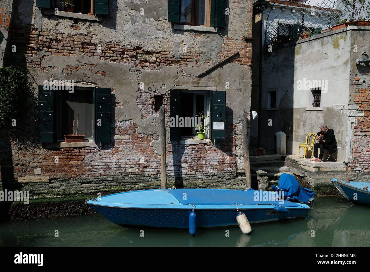 A man plays his guitar along a canal in Venice Stock Photo
