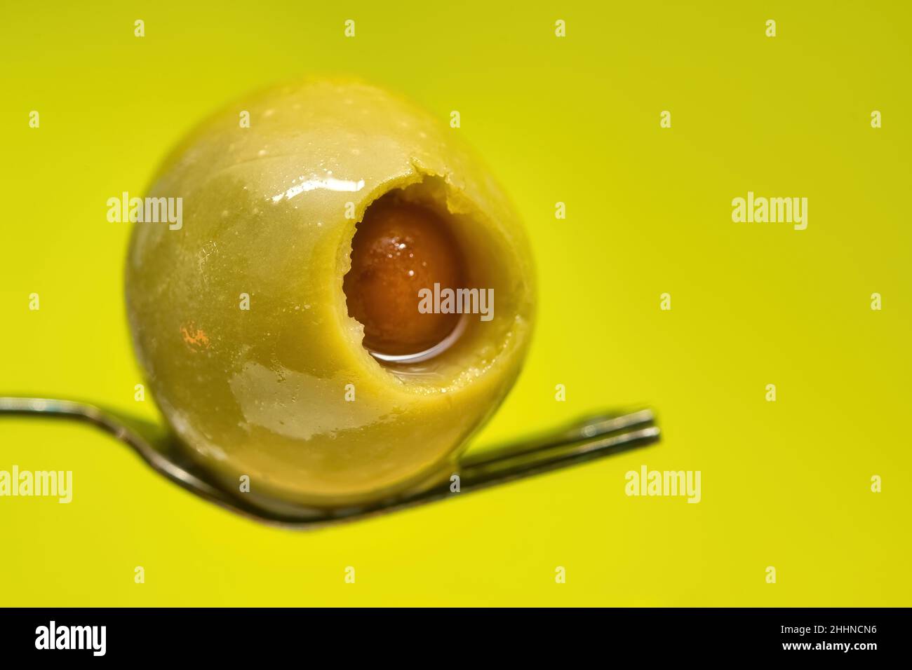 Stuffed olive over a small fork, macro photography Stock Photo