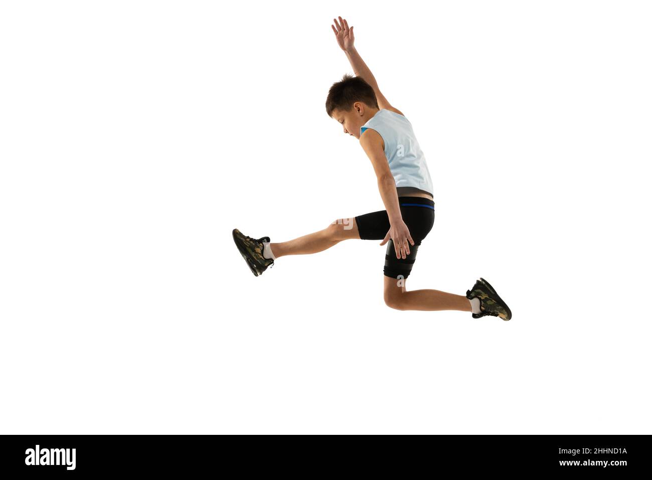 Fullength side view portrait of young boy, running athlete training