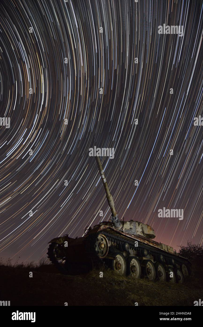 A Star trail and an abandon tank in the background Stock Photo