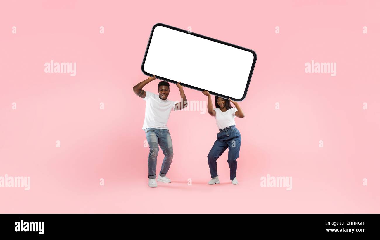 Black couple holding heavy white empty smartphone screen Stock Photo
