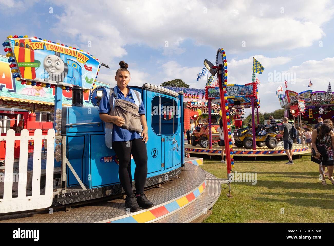 Funfair worker; Fairground ride operator  UK, standing by a fun fair ride,  Hertfordshire UK Stock Photo