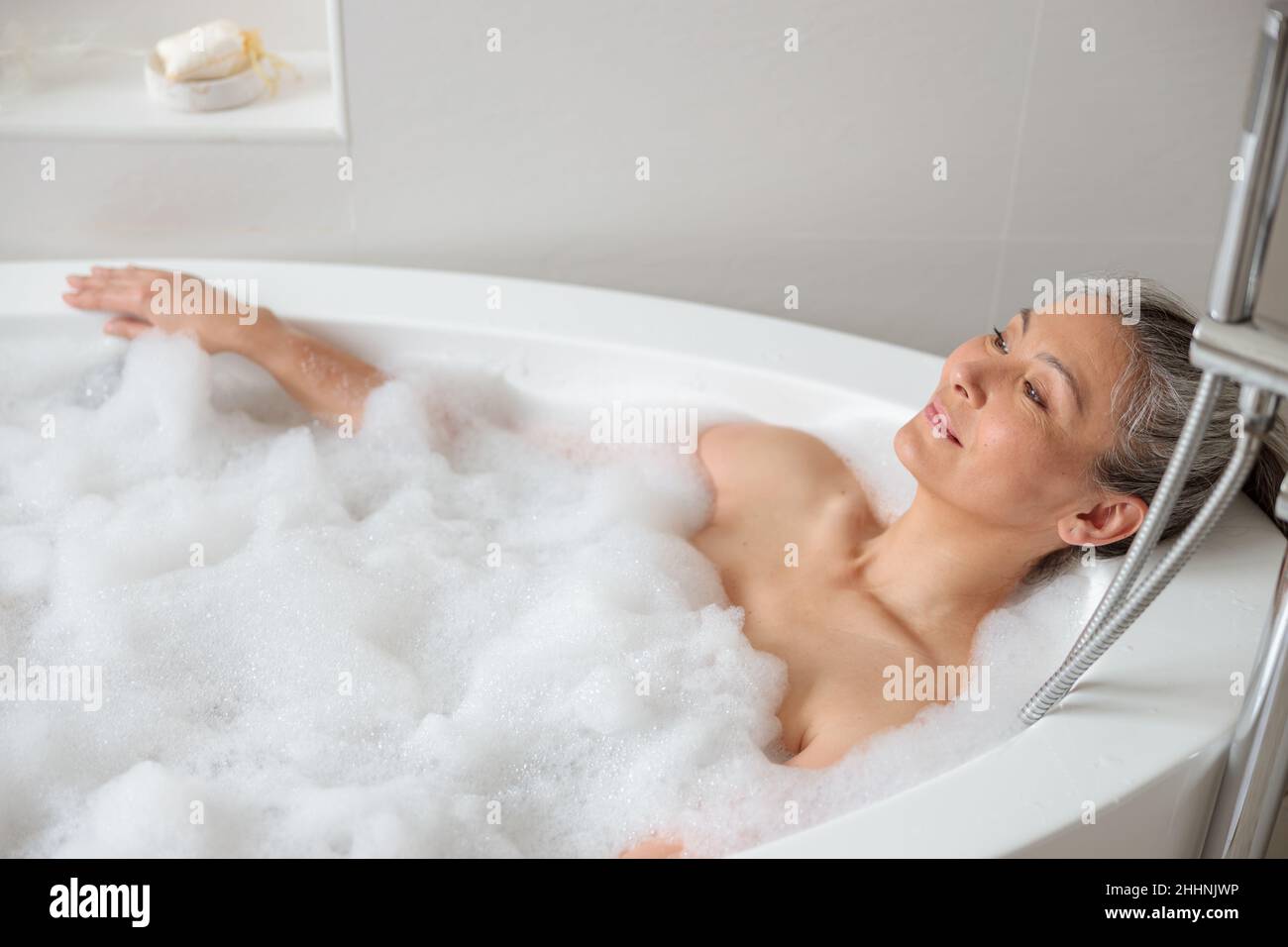 Female lying in the bathtube in spa Stock Photo