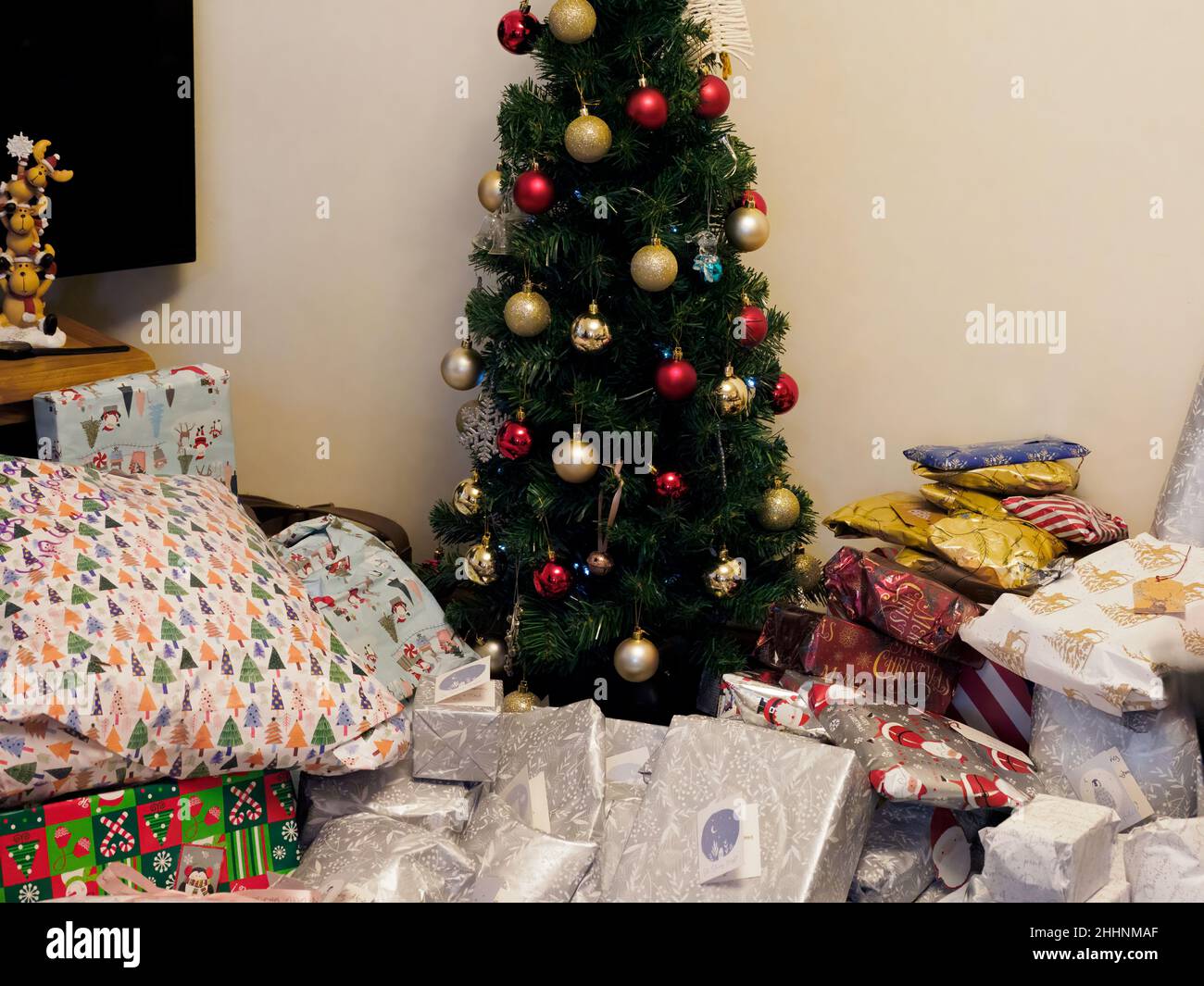 Disorganised pile of presents around a Christmas tree, UK Stock Photo