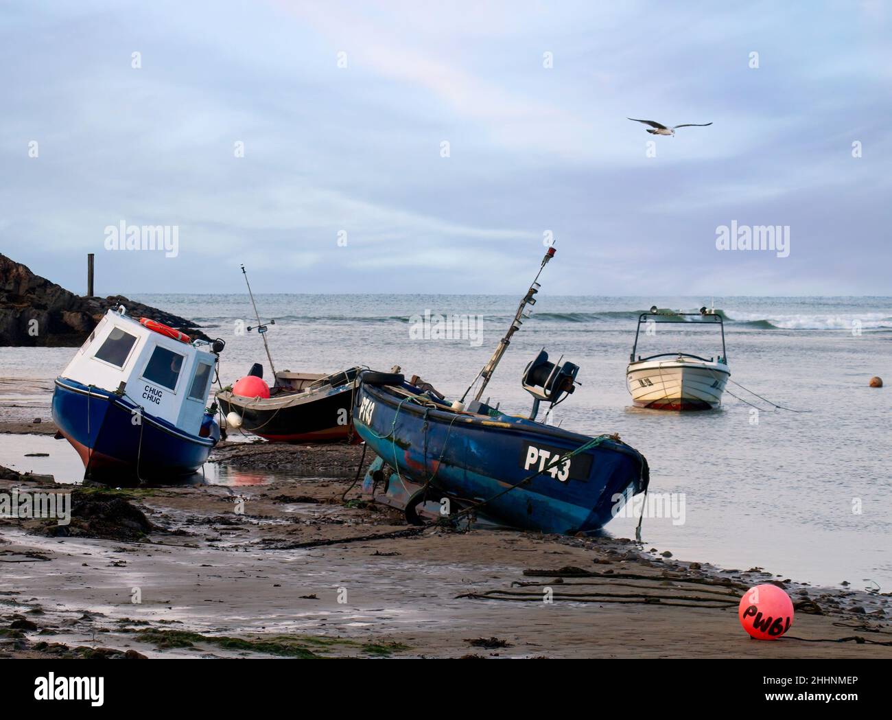 Small fishing boats at low tide on a tidal harbour, Bude, Cornwall, UK Stock Photo