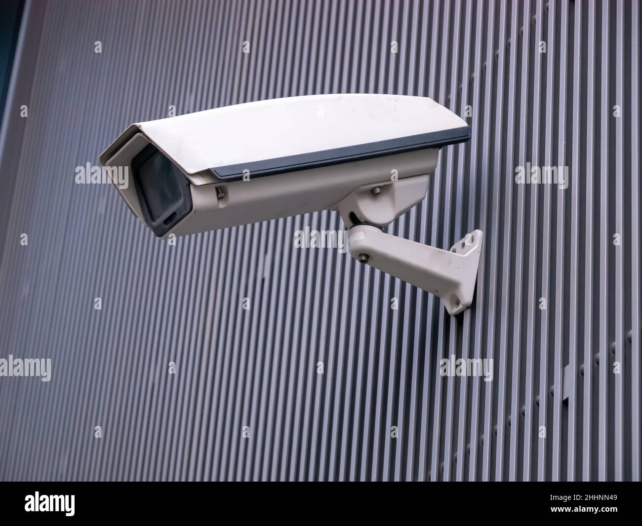 CCTV camera isolated on gray striped background. Stock Photo