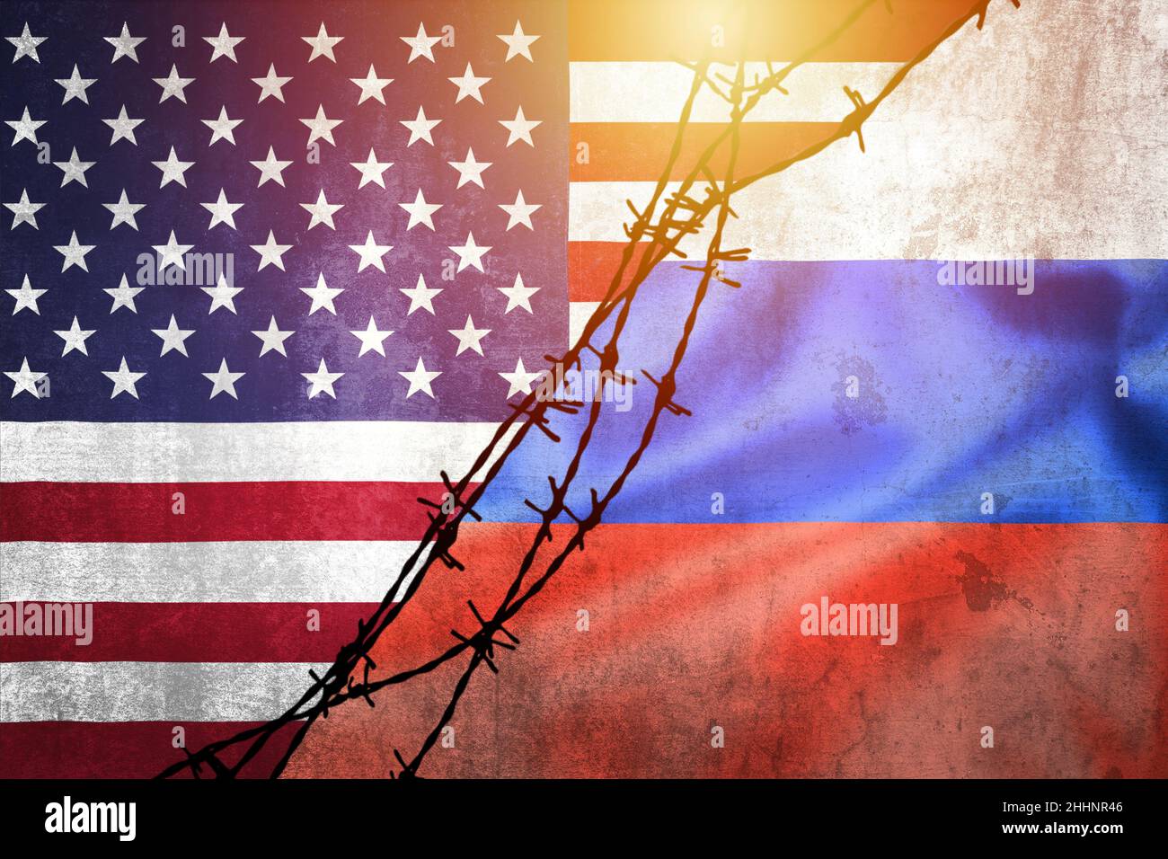Grunge flags of Russian Federation and USA divided by barb wire sun haze illustration, concept of tense relations between west and Russia Stock Photo