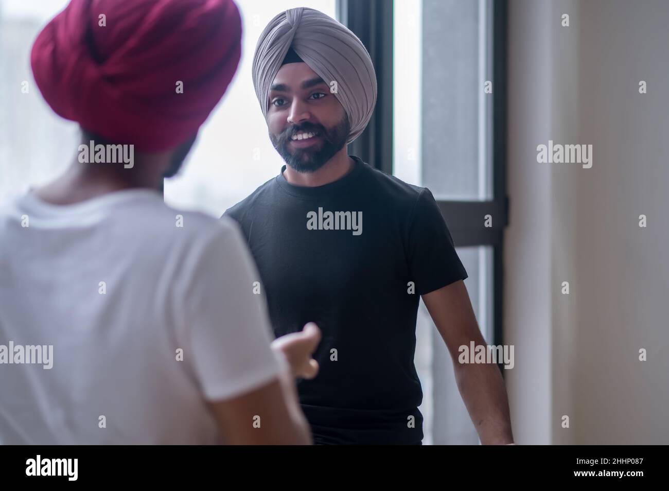 Two men in turbans talking and looking involved Stock Photo