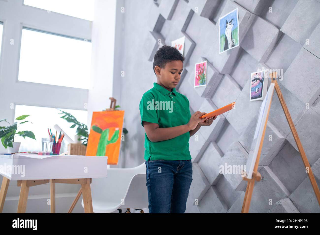 Boy with tablet standing near drawing easel Stock Photo Alamy