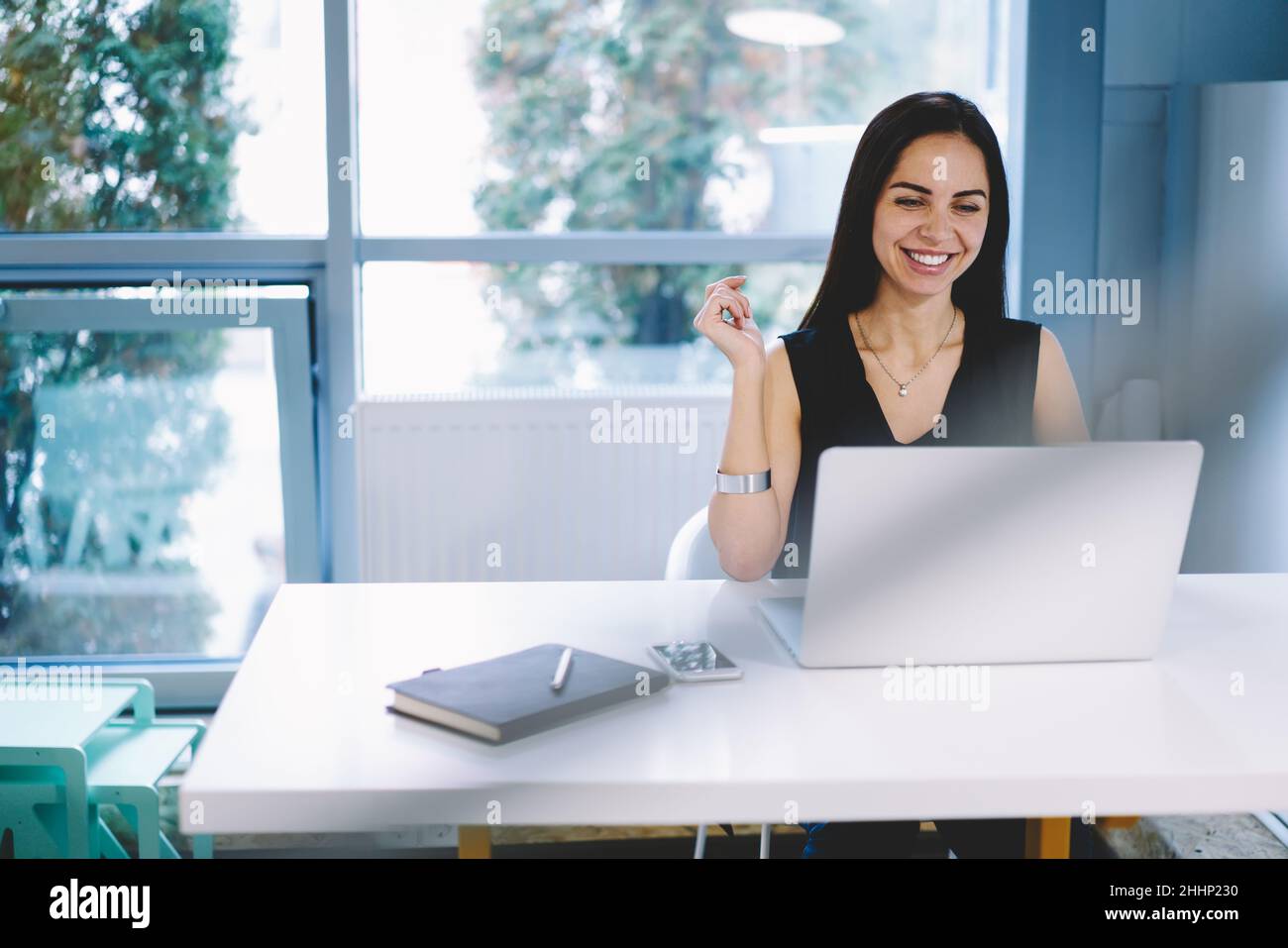 Smiling businesswoman working on laptop Stock Photo