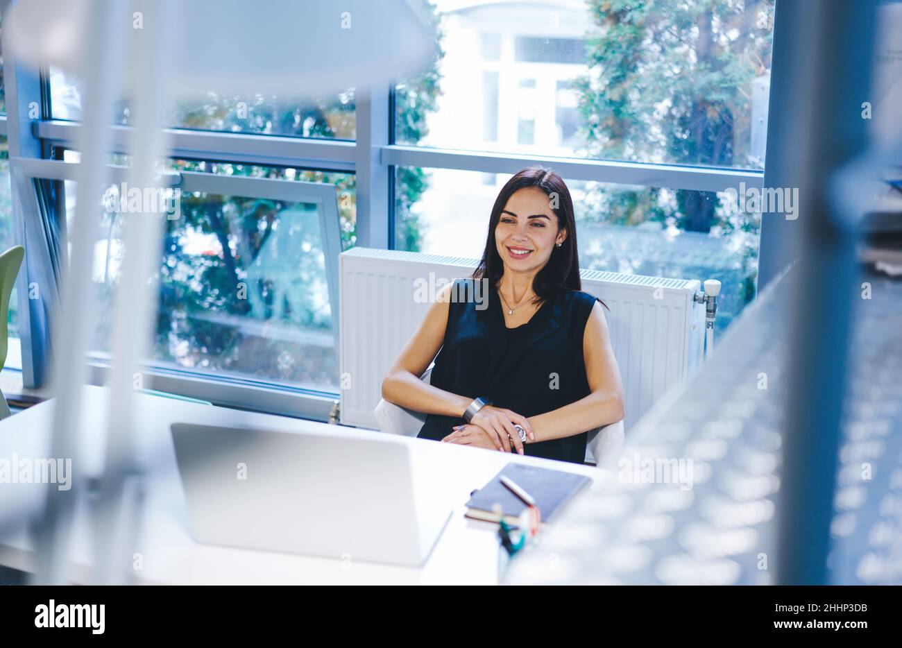 Smiling woman resting in armchair at work Stock Photo