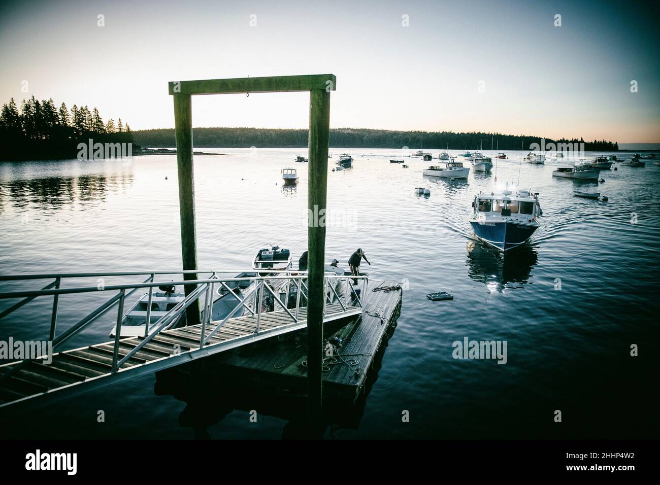 Lobster boat driving into the dock in Owl's Head, Maine Stock Photo