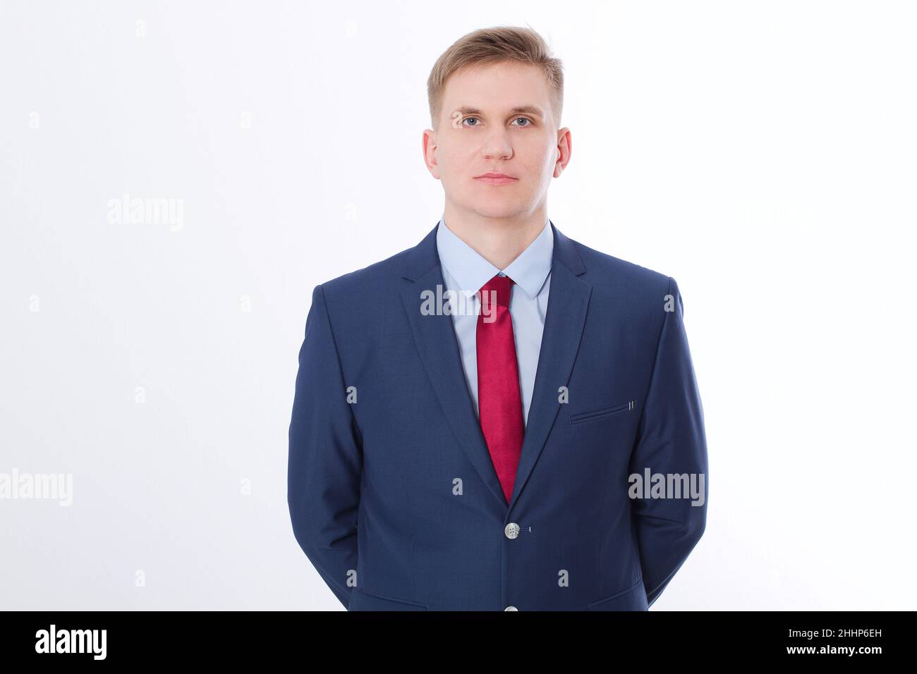 Serious businessman in blue suit and red tie isolated on white ...