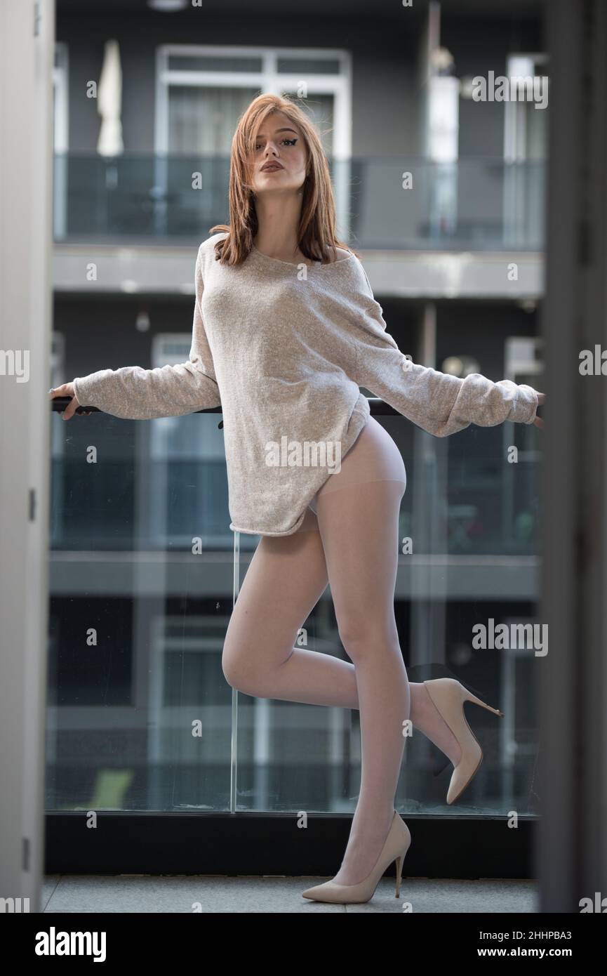 Attractive woman in white pantyhose , high heels and long legs posing  challenging in the balcony. Classic and erotic outdoor boudoir scene.  Sensual Stock Photo - Alamy