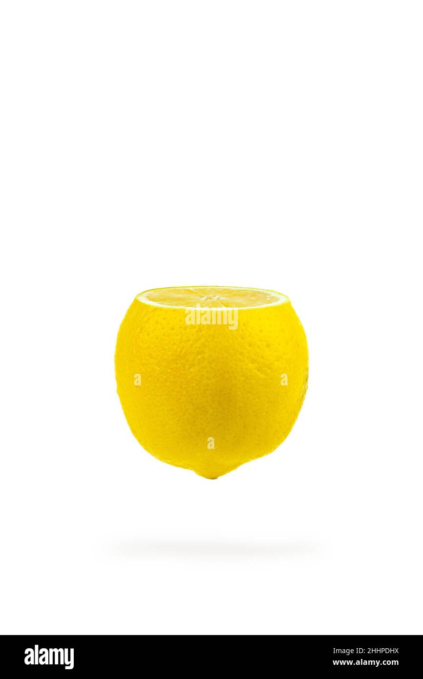 Ripe juicy flying yellow lemon on white background. Creative summer minimalistic background Stock Photo