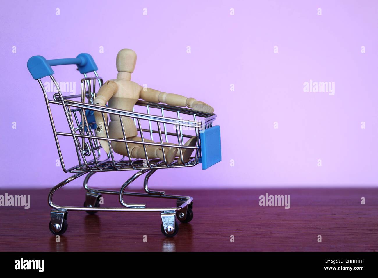 Shopping, business concept. Wooden doll inside shopping trolley Stock Photo