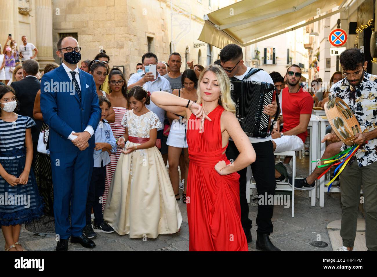 LECCE, ITALY AUGUST, 19, 2021, Woman in red dress dancing barefoot