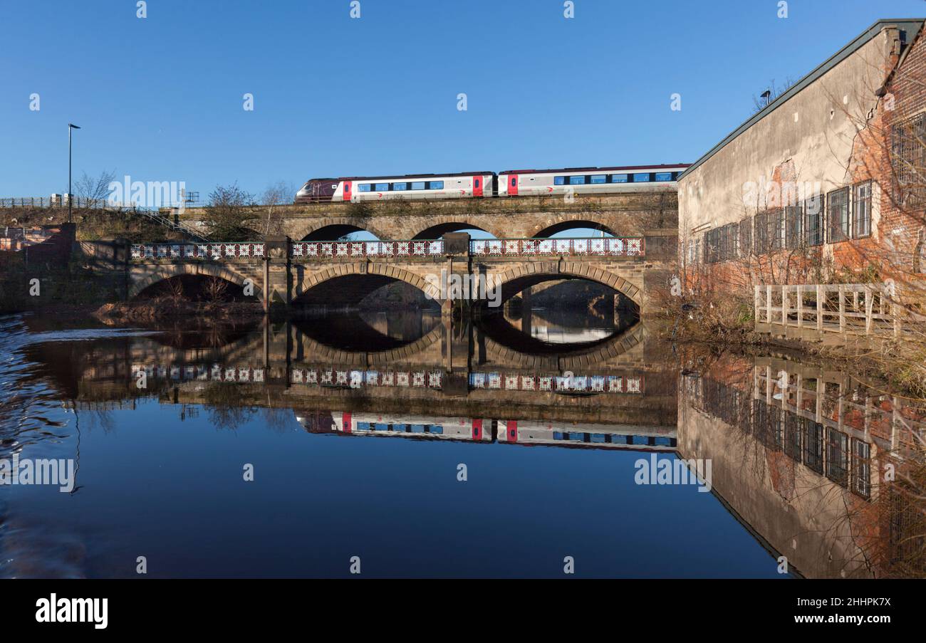 Arriva Crosscountry Trains class 220  train crossing the viaduct at Burton Weir, River Don,  Attercliffe, Sheffield, reflected in the water below Stock Photo