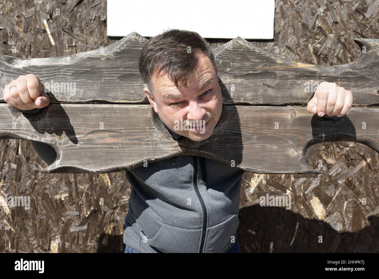 Portrait of man in wooden pillory outdoor Stock Photo