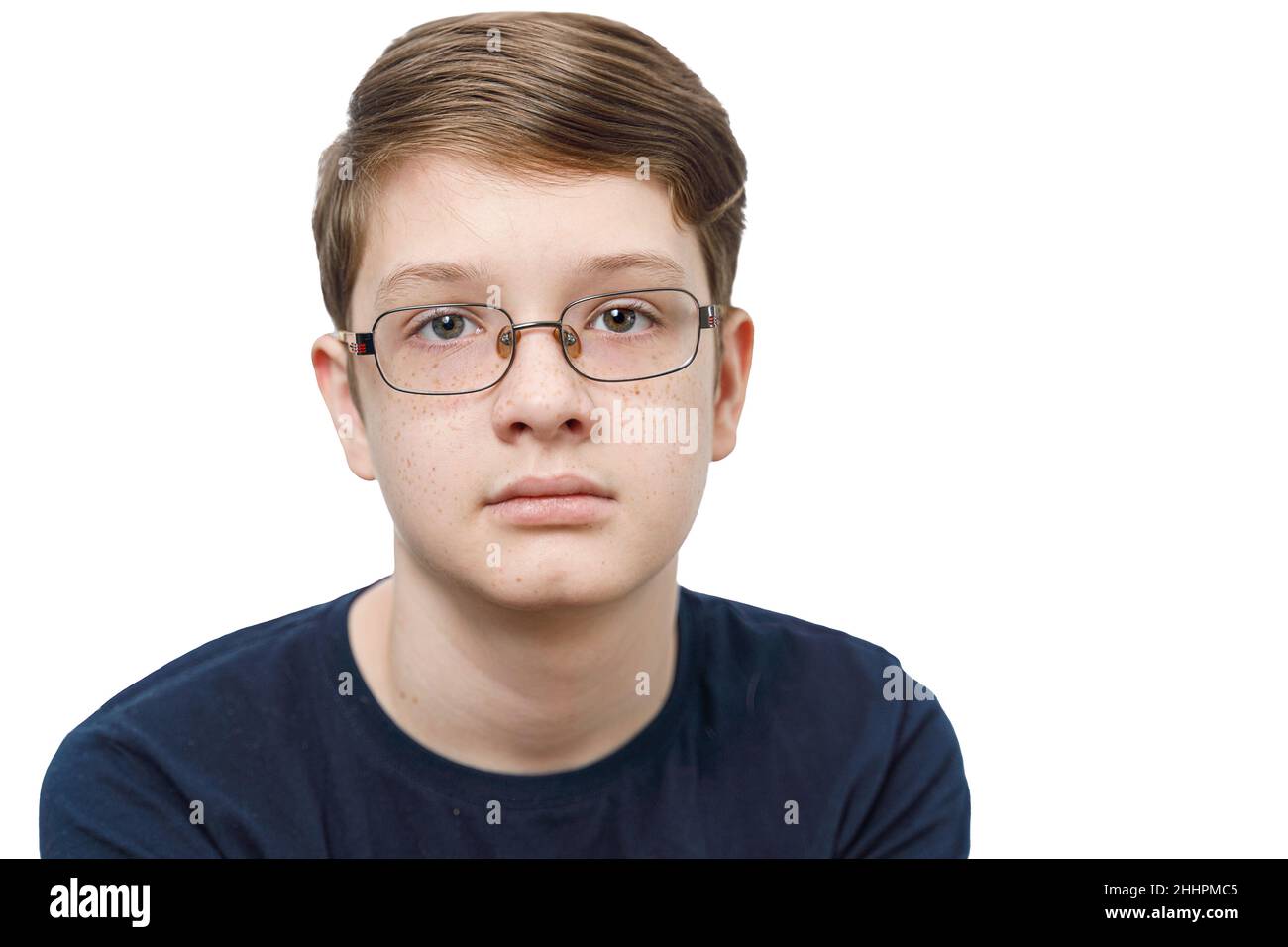 Teenager boy with freckles on a face with classic glasses, isolated in white background. Healthy people concept. Stock Photo