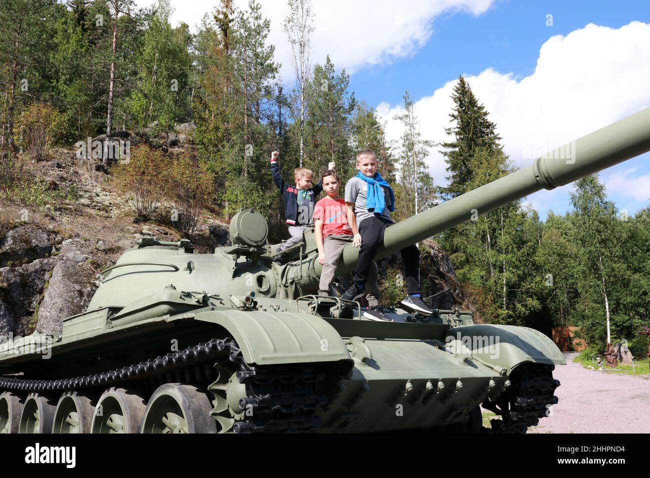 Children sitting on gun of t-62 tank at Gora Filina, Karelia Stock Photo