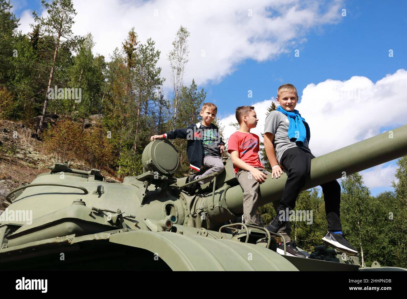 Kids sitting on gun of t-62 tank at Gora Filina, Karelia Stock Photo