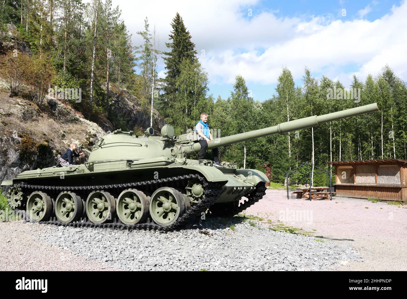 Boy sitting on gun of t-62 tank at Gora Filina, Karelia Stock Photo