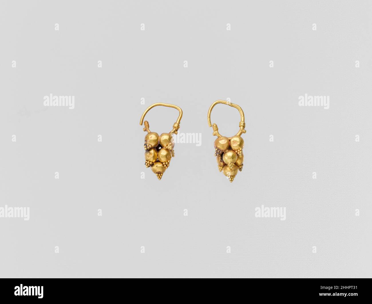 Gold earring with clustered spheres and pyramidal granulation 2nd–3rd century A.D. Roman Gold earrings with mulberry ornament.. Gold earring with clustered spheres and pyramidal granulation. Roman. 2nd–3rd century A.D.. Gold. Imperial. Gold and Silver Stock Photo