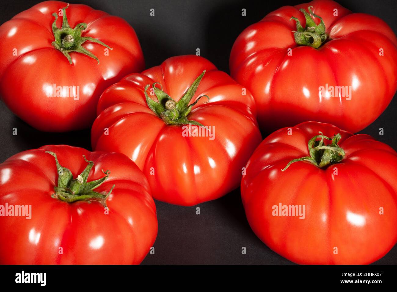 pink tomato on black background Stock Photo
