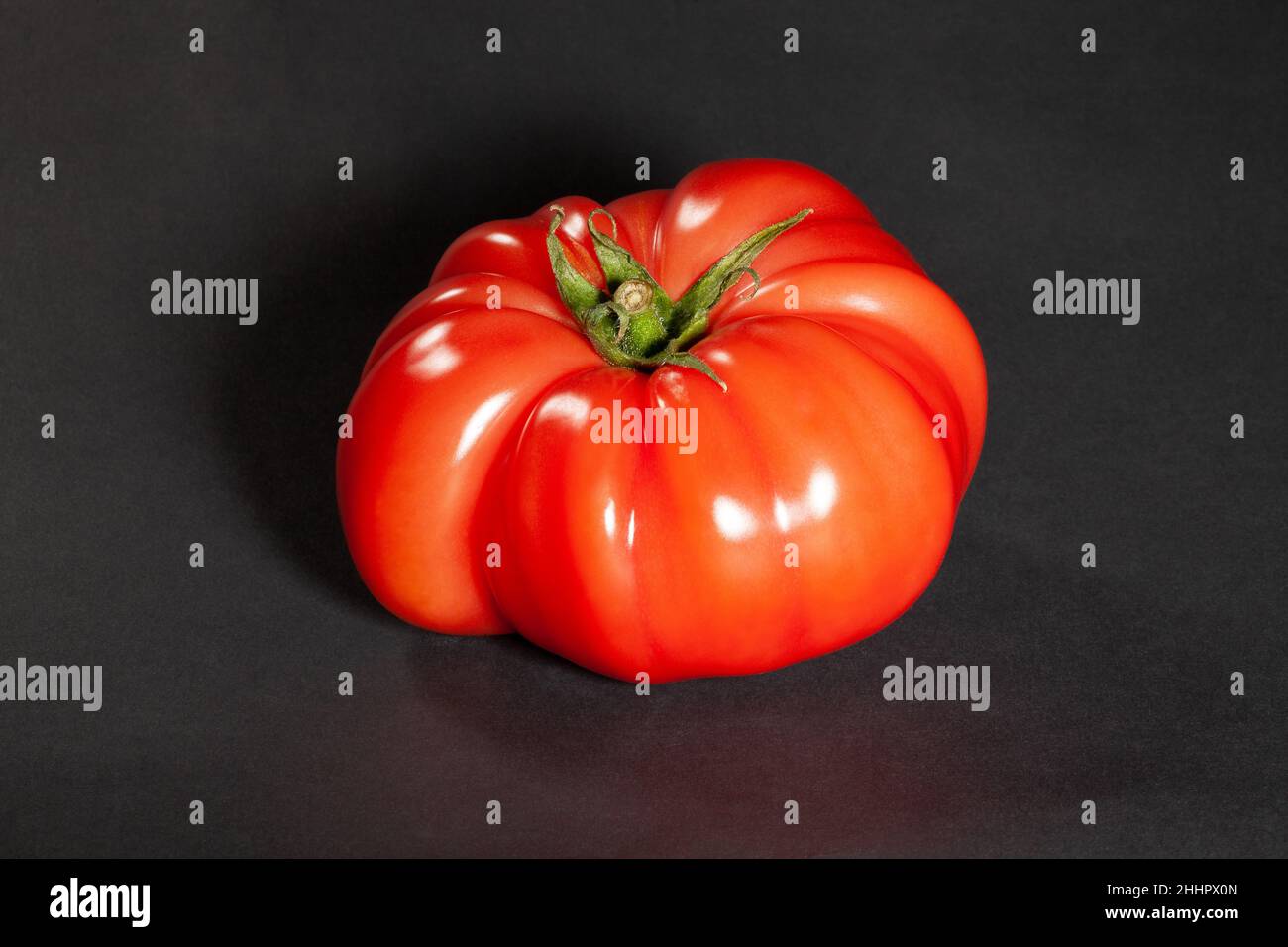 pink tomato on black background Stock Photo