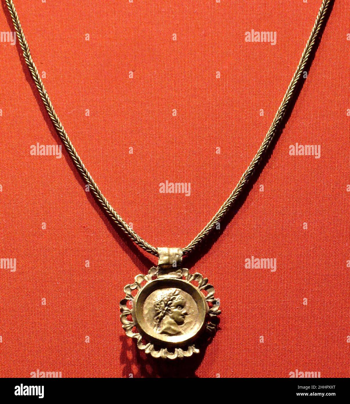 Chain with a pendant bearing an emperor's profile in an openwork frame A.D. 3rd century Roman Period The medallion here imitates a coin portrait of an emperor, and probably dates to roughly the mid third century when the latter began sometimes to be incorporated in jewelry. It has been noted that the sheet gold pendant is so flimsy that it might not have originally hung on this particular chain, which is, by contrast, rathe sturdy.. Chain with a pendant bearing an emperor's profile in an openwork frame  547921 Stock Photo