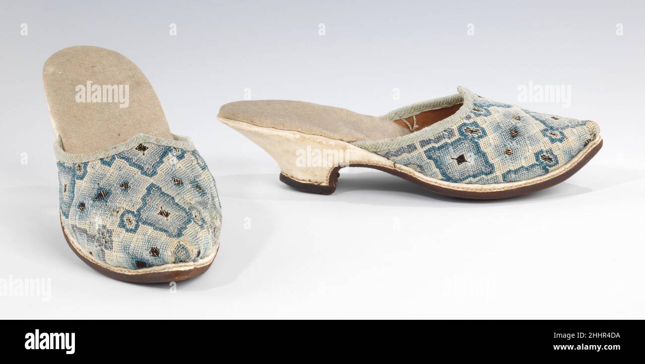 Mules early 18th century European Mules were a popular form of at-home footwear in the 17th and 18th centuries for both men and women. This fairly conservative example of ladies' mules features a low heel and good quality embroidery in tastefully subdued tones. This style of embroidery is known as Florentine work, a type of flame stitch canvas work with varied stitch lengths.. Mules  156202 Stock Photo