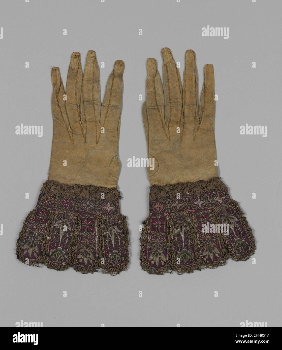 Pair of gloves first half 17th century British The highly skilled maker who executed these gloves chose an intricate design—floral yet geometric—that alludes to the more simple versions found in early seventeenth century pattern books. As scholars have pointed out, pattern books for needlework and lacemaking, which were marketed towards women of the middling classes, presented an opportunity for upward mobility at a time when wealth was partially measured in fine possessions. The elite classes might hire artists and professionals to design and carry out, and thus distinguish their own embroide Stock Photo