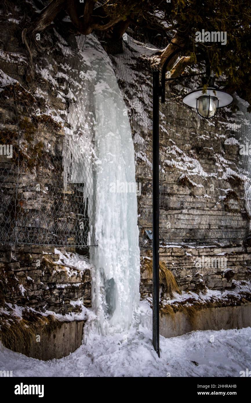 Frozen waterfall over a brick wall Stock Photo