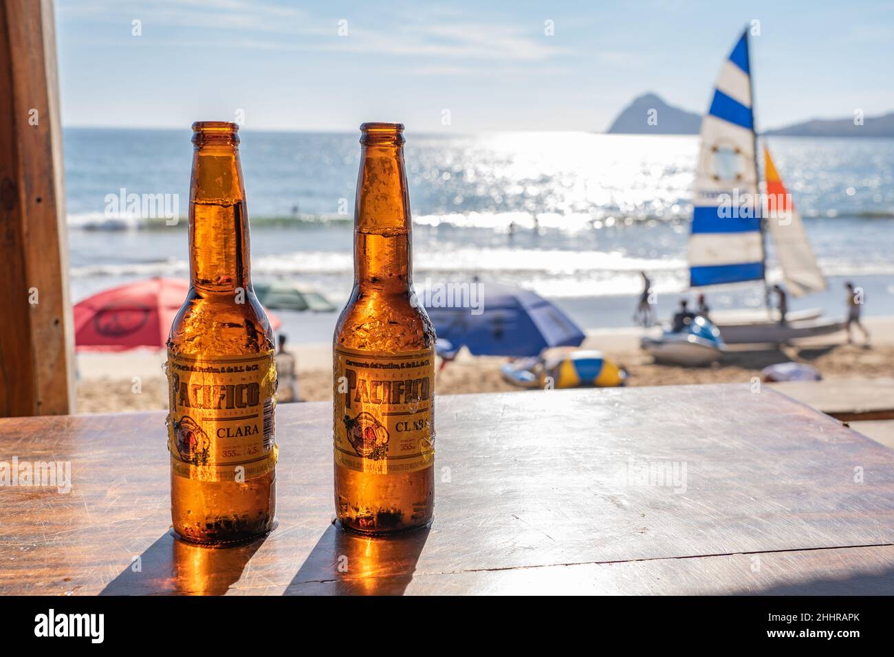 Pacifico beer at beach cafe with sailboat and ocean view in Mazatlan