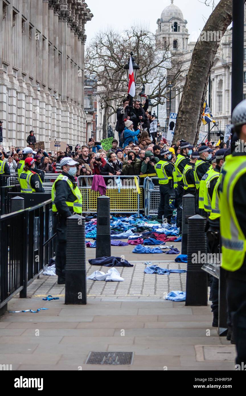 LONDON, ENGLAND- 22 January 2022: NHS uniforms thrown towards downing street at the NHS100K protest against vaccine mandates Stock Photo