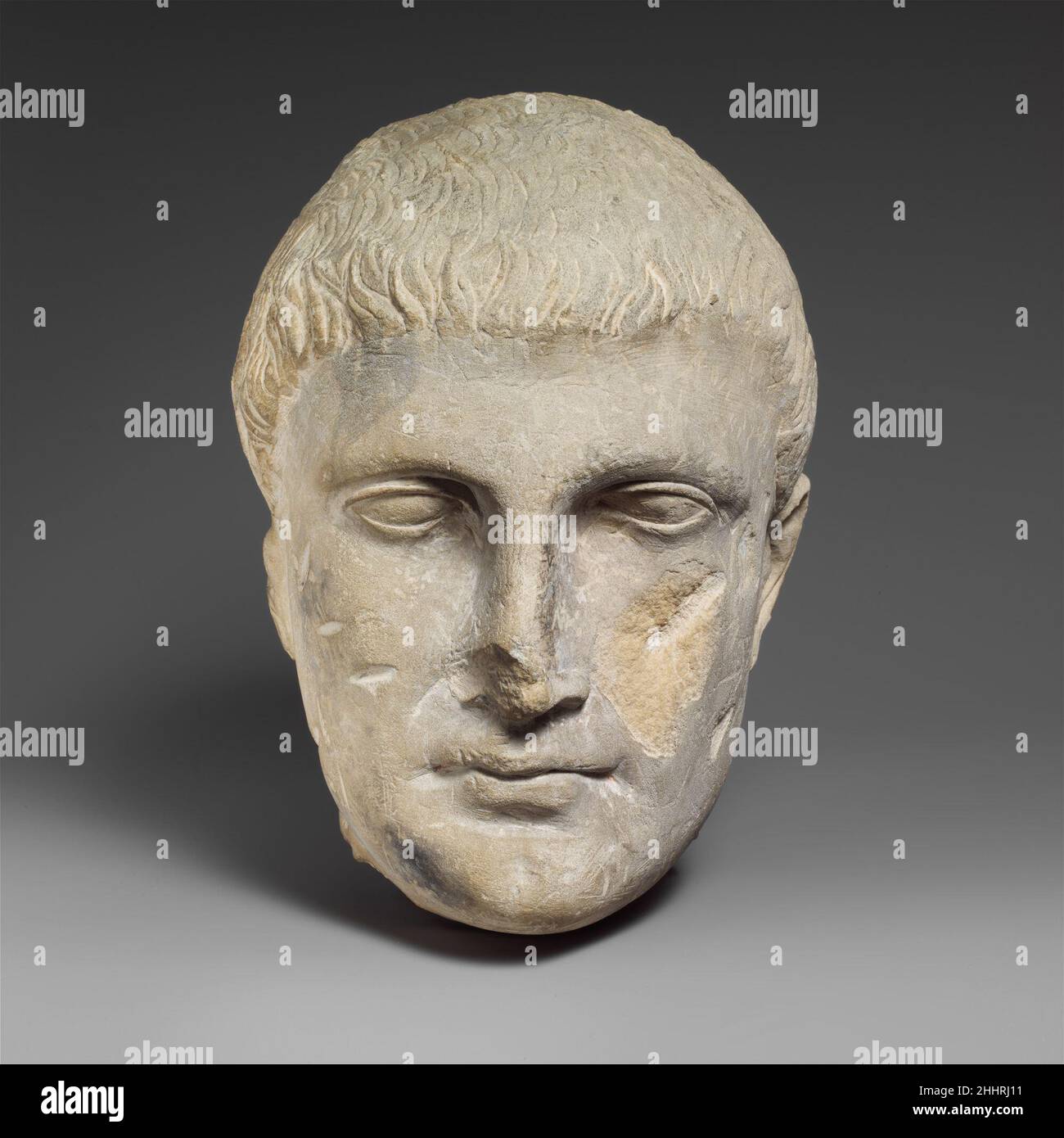 Limestone male head 2nd century B.C. Roman, Cypriot The facial expression is severe and a small wrinkle begins at the nose. There is a dimple on the chin and a deep depression under the lower lip. The hollow of the eyes, against the nose, is very deep-set.. Limestone male head  242345 Stock Photo