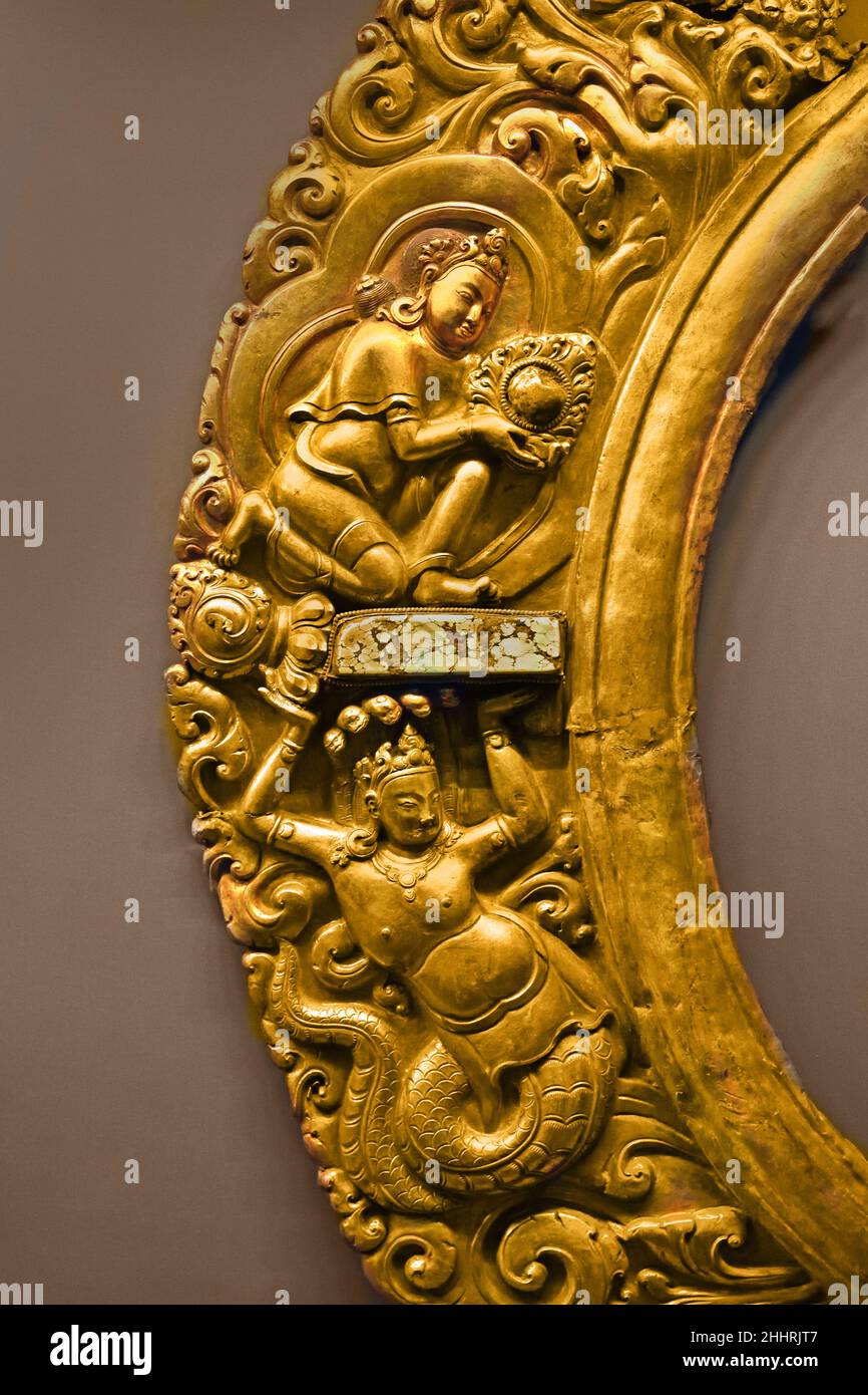 Manidhara and Nagaraja Central Tibet 15th Century Tibetan ( Fragment, part of the luminous halo of a statue, typical production of Newar artisans operating in Tibet 15th century. Climbing plant draws the volutes inside which are placed the figures of a Nagaraja (king of snakes and protector of the treasures contained in the depths of the waters) and Manidhara (the Jewel-bearer). Manidhara and Nagaraja together refer to the myth of Nagarjuna.) Stock Photo