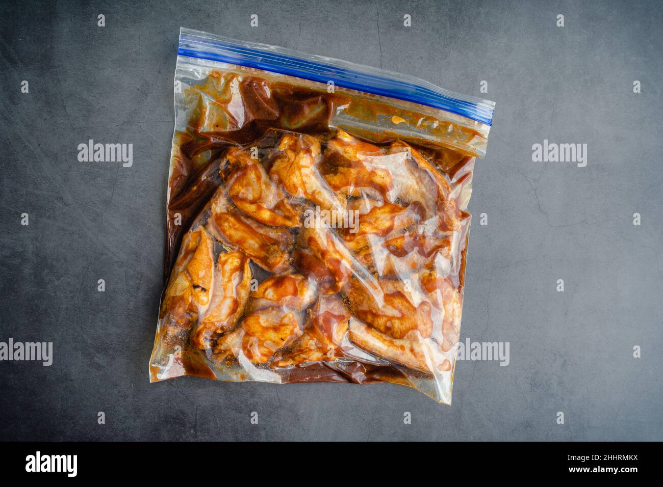 Raw Chicken Wings Marinating in a Plastic Bag: Uncooked chicken wings and marinade in a ziplock bag Stock Photo