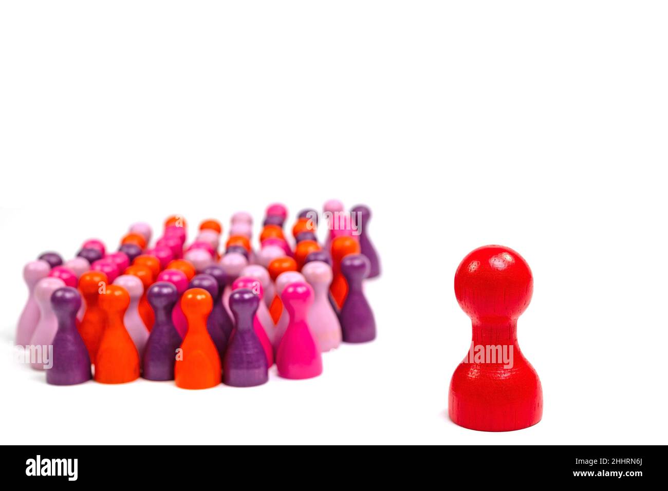 Lots of colorful small wooden cones and a large red wooden cone against a white background Stock Photo