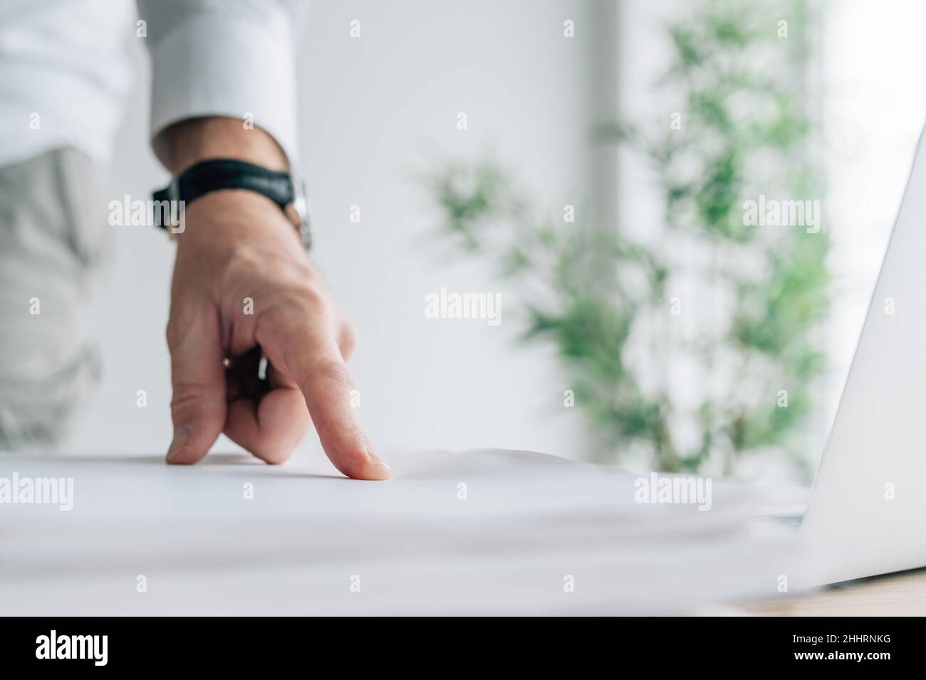 Businessman pointing finger to a document on office desk, selective focus Stock Photo