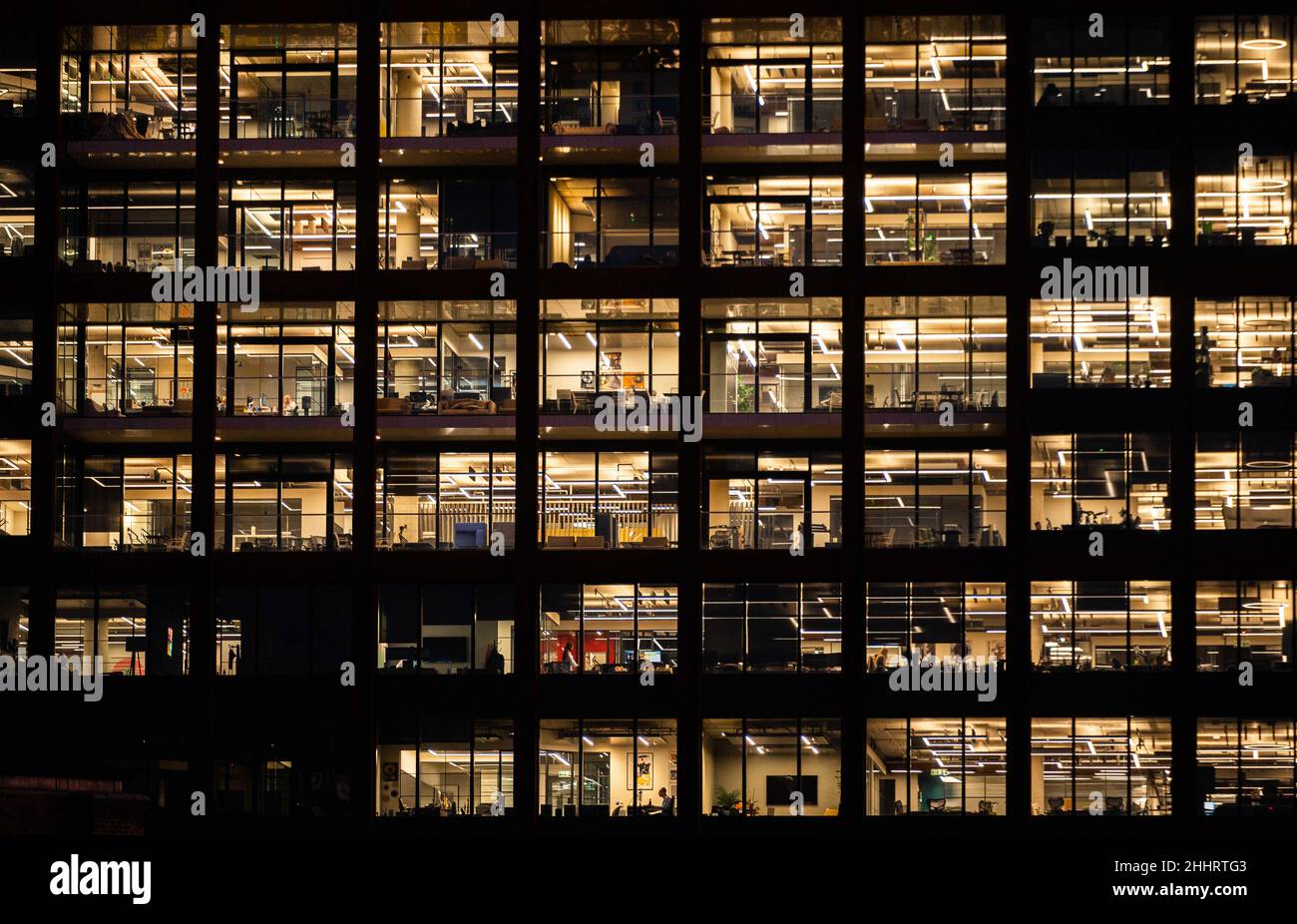 Office windows in an office block at night Stock Photo